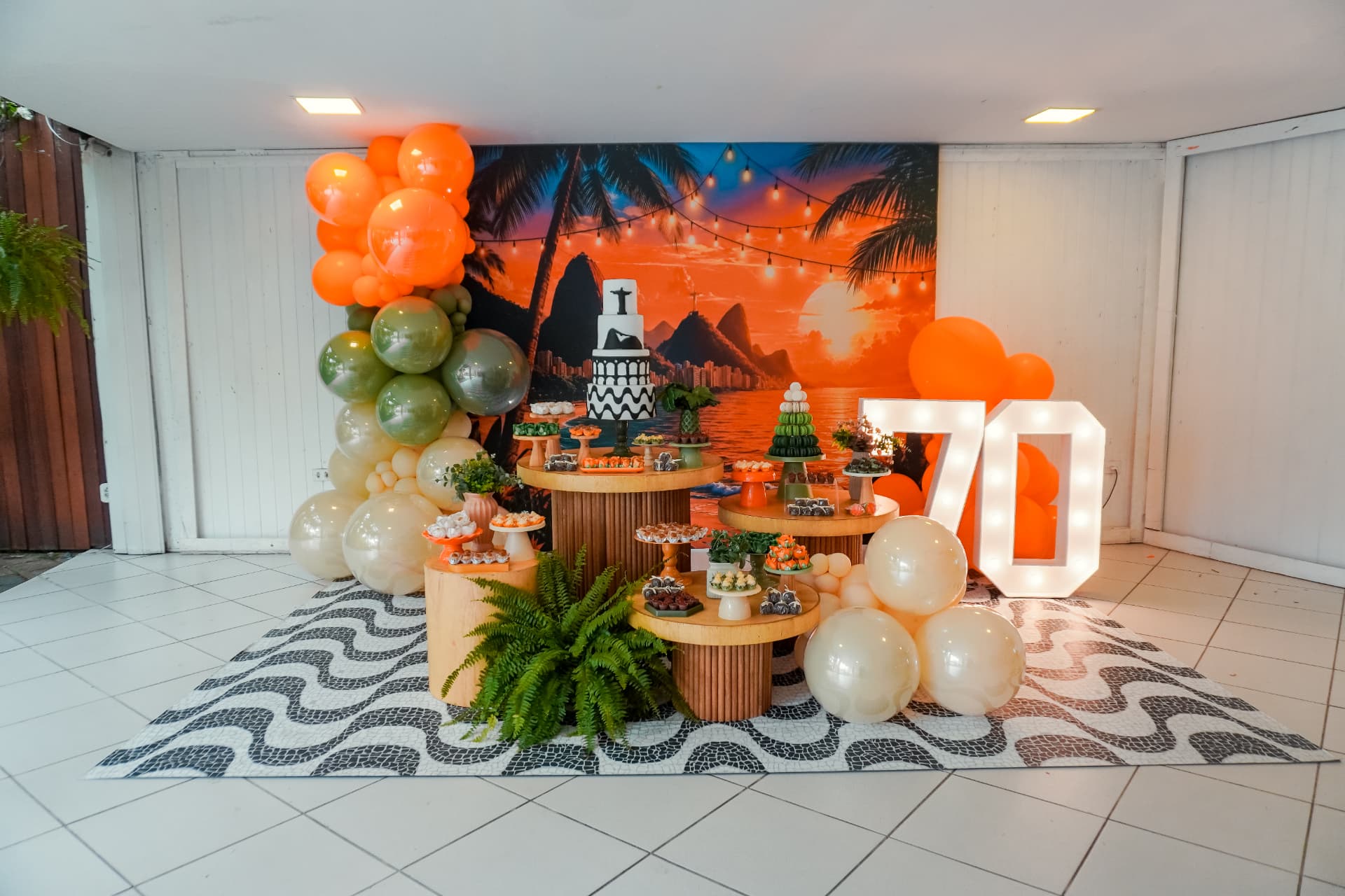 Cenário completo de festa de 70 anos com balões e mesa de doces