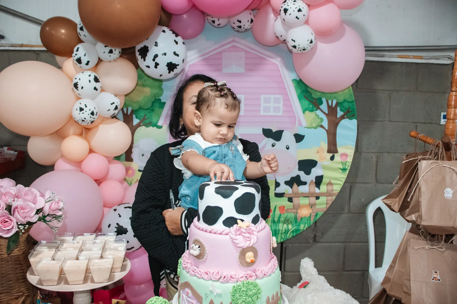 Aniversariante junto ao bolo e à decoração