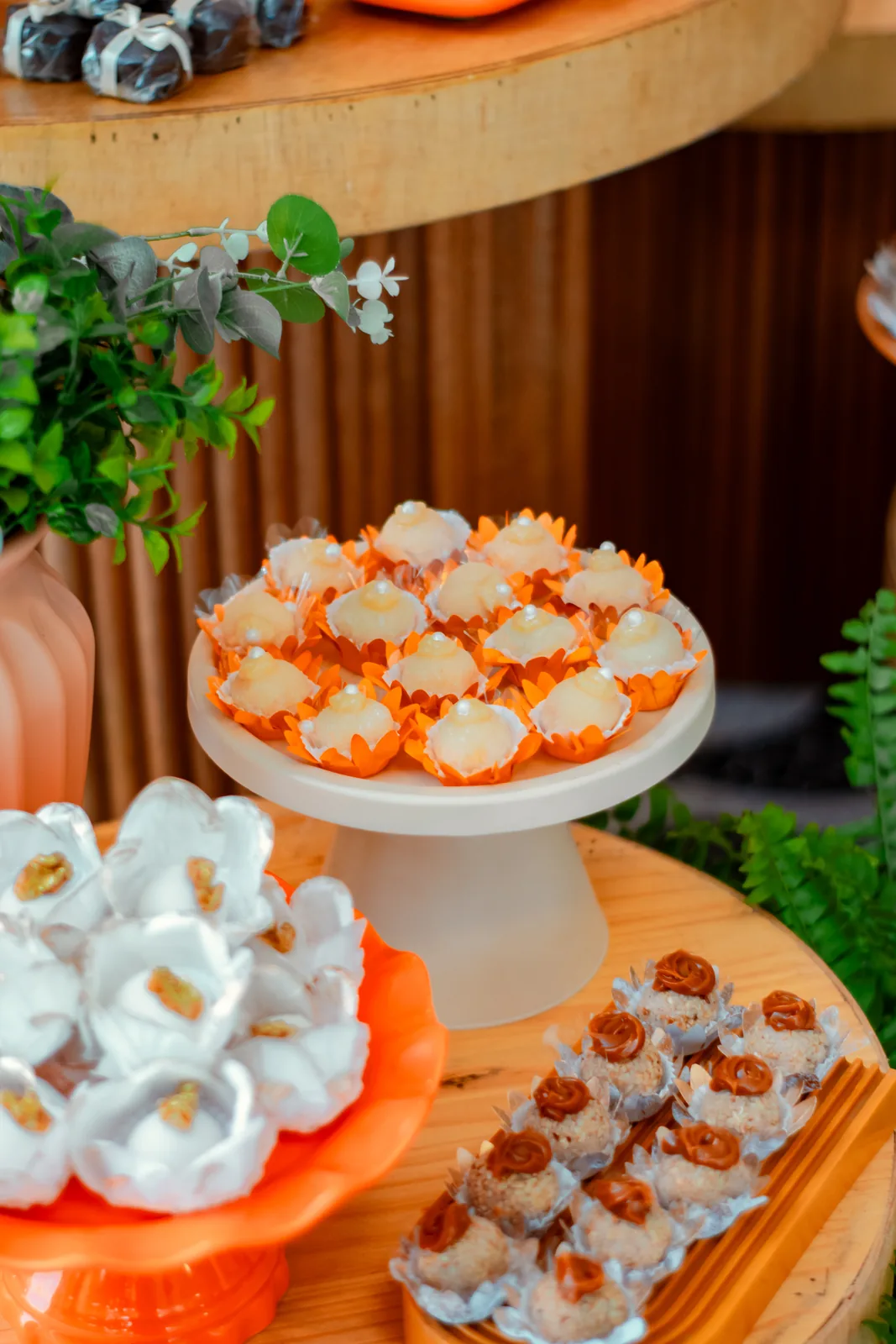 Mesa de doces em tons de laranja da festa de 70 anos