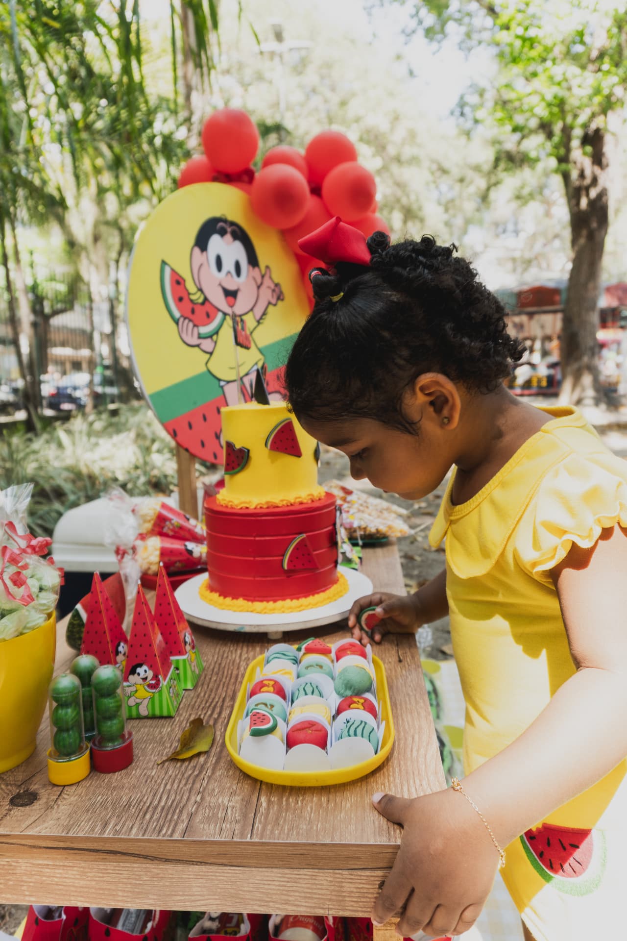 Criança escolhendo doces na mesa da festa
