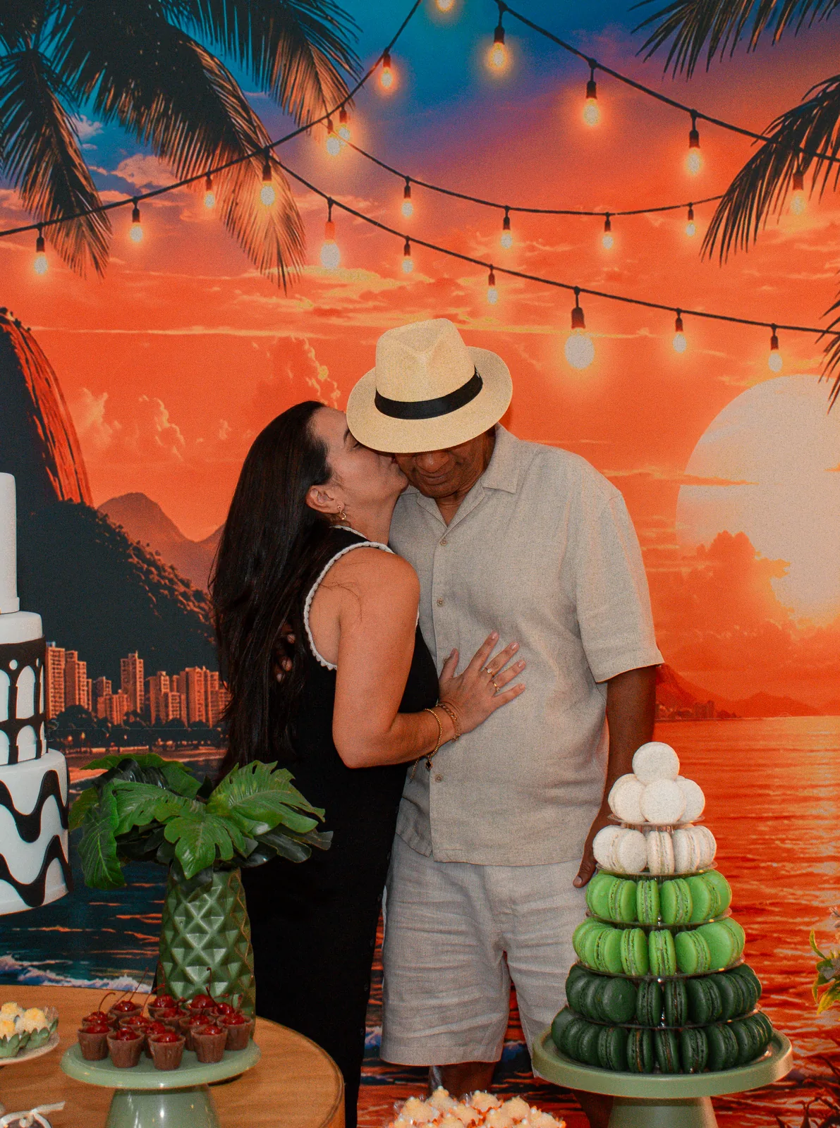Casal celebrando diante da decoração da festa